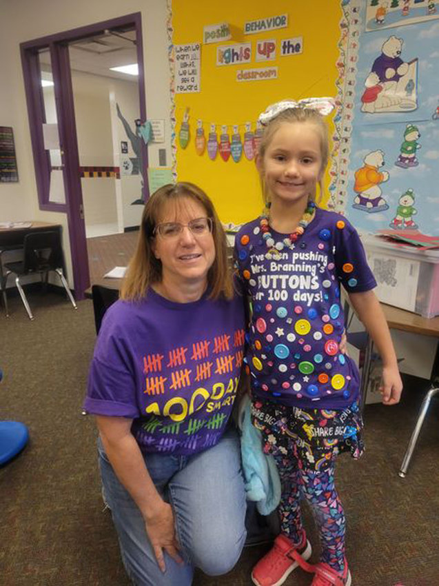 Boyer Valley first grade student Kinley Cogdill poses with Mrs. Branning to show off her 100th Day shirt, which says, &quot;I've been pushing Mrs. Branning's buttons for 100 days.&quot;