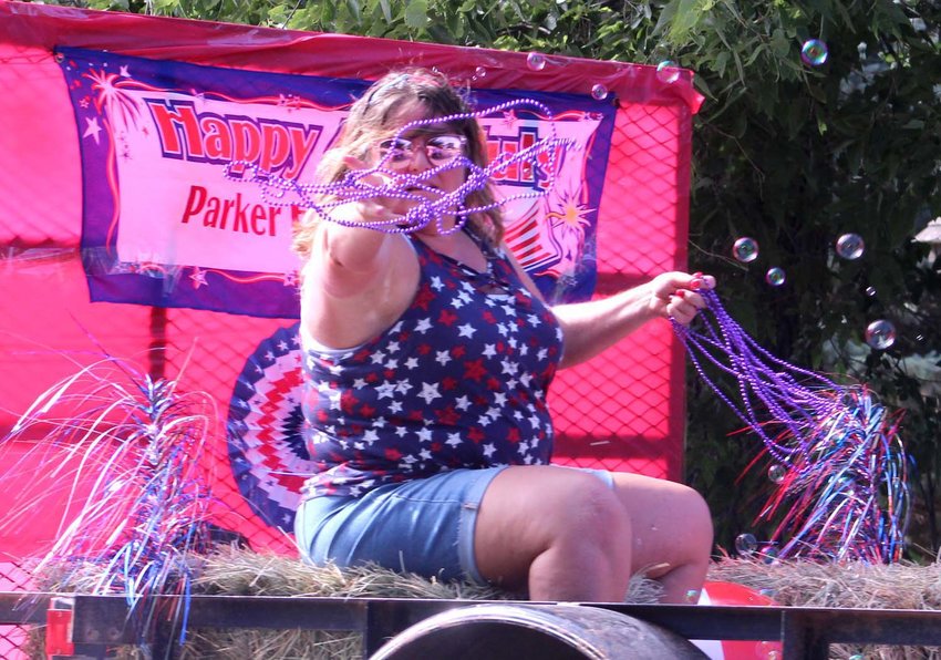 Teresa Parker threw beads from the Parker Family Farm float in Mapleton's 4th of July parade.