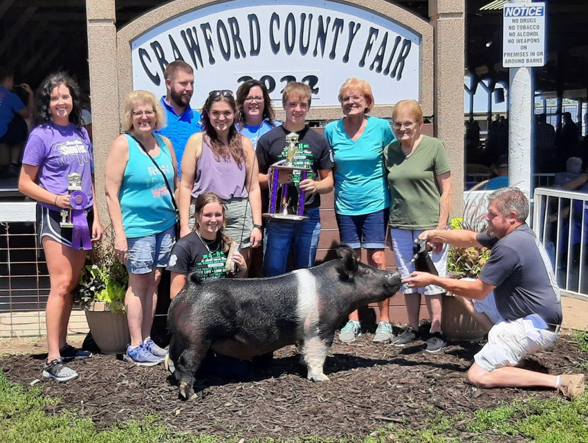 Boyer Rooter member, Camryn Boyle,  (kneeling with her Barrow)  Had the Reserve Champion Market Barrow and the Reserve Champion Breeding Gilt.  Kane Boyle is holding the trophy, received several purple ribbons on his swine projects and had the Champion Duroc market hog.