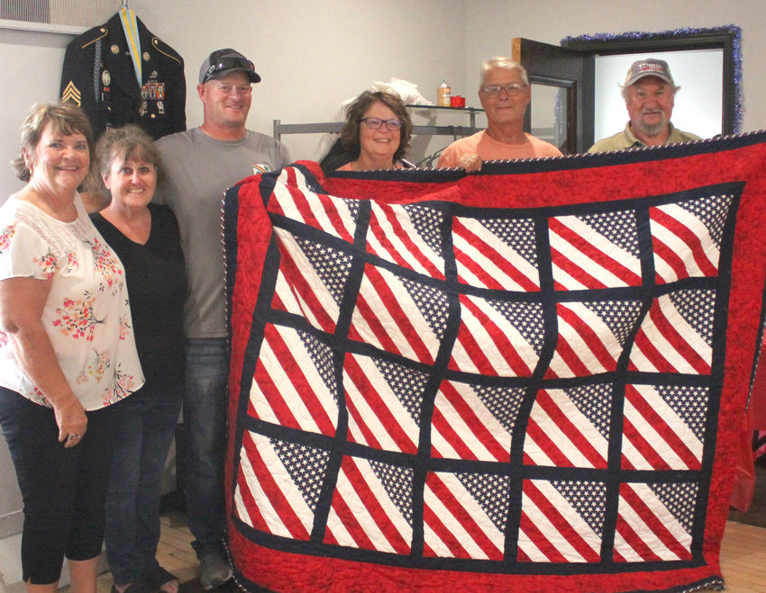 The family of Eric Wendt (third from left) threw a surprise retirement party for the United States Army serviceman on Sept. 24 at the Cottonwood Event Center in Dunlap.  The family created and put together a 'Quilt of Valor&quot; honoring Wendt for his service.  Shown above include, from left, Sheryl Wendt, Brenda Wendt, Eric Wendt, Dee Kuhl, Chuck Wendt, and Dave Wendt.  Not pictured: Barb Wendt, Mike Wendt, Kris Pauley, Bruce Pauley.