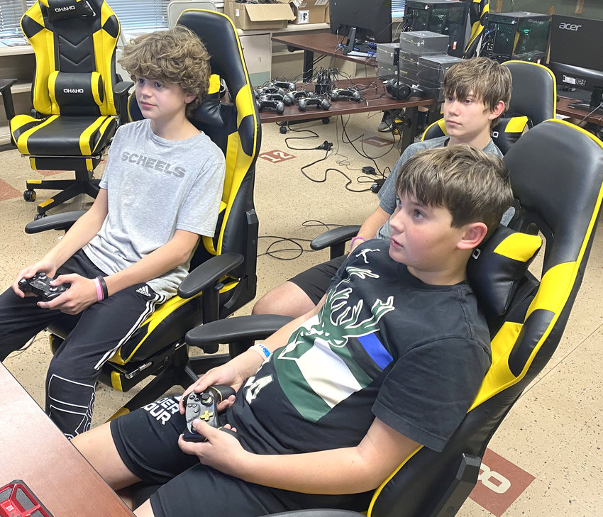 Kyson Ransom, Ryder Luth, and Ezden Hargens look at the screen during Esports practice.