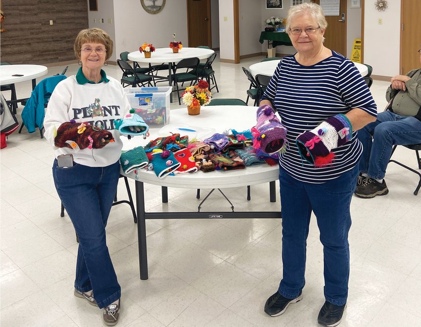 Melba Struble (left) and Carol Clausen (right) have been making twiddle muffs for a Lions Club project with the help of knitter Evelyn Marshall.
