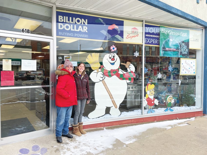 Mary Jane Zehner (left) and her granddaughter Shannon Queen (right) embraced the holiday spirit by taking nearly a week to hand paint and hand trace the Frosty the Snowman decorations that now sit in the storefront of Bonsall TV &amp; Appliance.