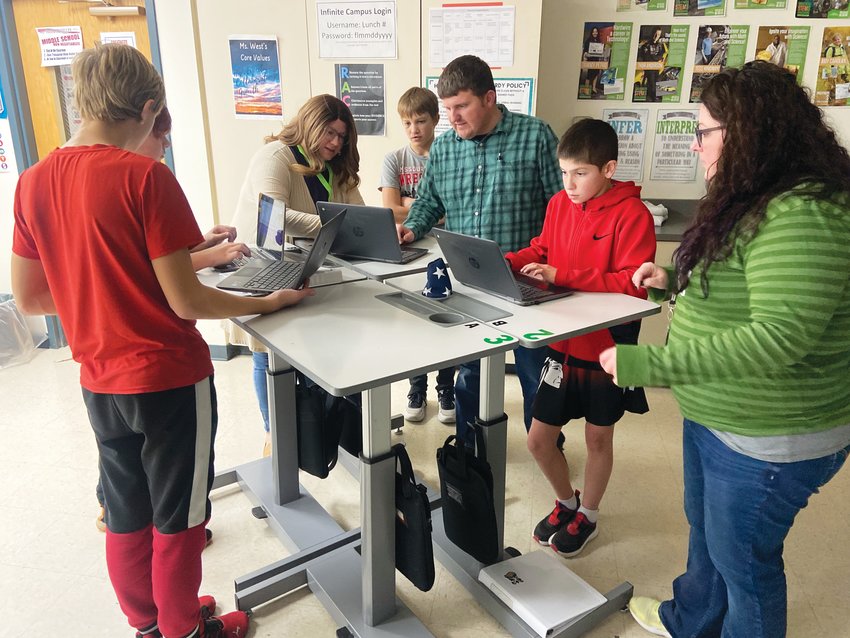 Erin Gorman (middle), who is the County Youth Coordinator for Iowa State's Harrison County Extension and Outreach office, teaches students to code on Friday at Missouri Valley Middle School.
