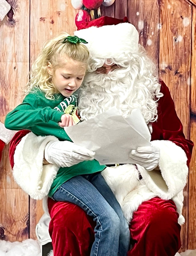 Jules Jurgensen goes over her Christmas list with Santa when he was in Schleswig on Dec. 3.