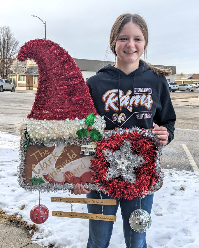 Claire Smallwood holds the Griswold traveling trophy award as the Smallwoods were the Griswold winners in Mapleton's Holiday of Lights contest.