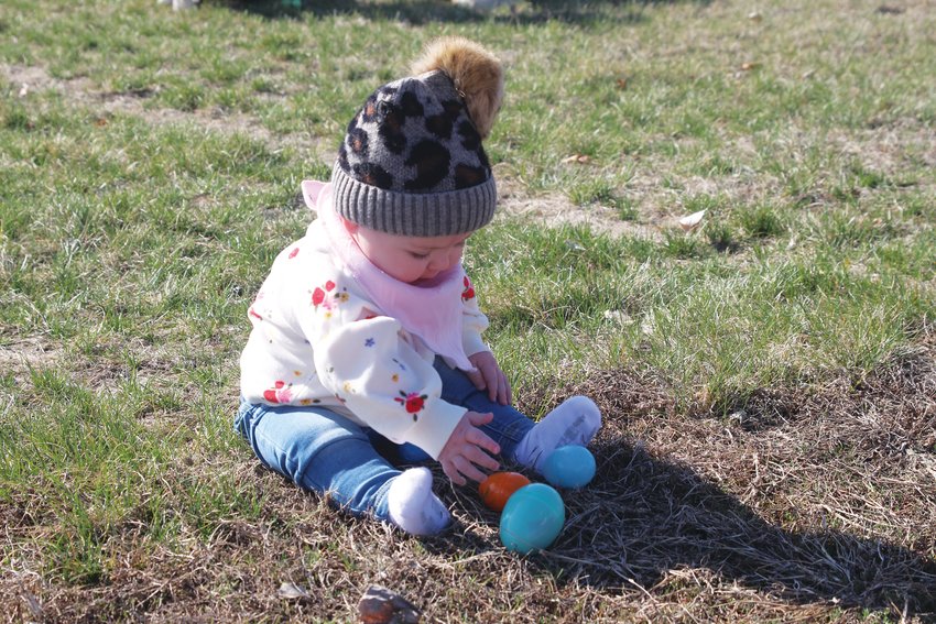 Adelynn Miller ponders which egg to grab during the Easter egg hunt at the Boyer Valley Sports Complex in Dunlap on April 8.
