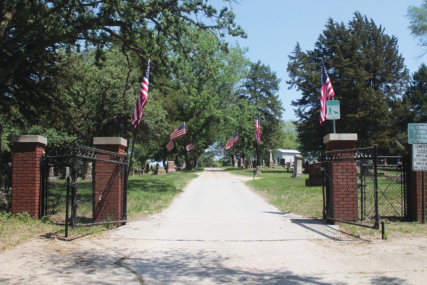 An avenue of flags can be seen at the entrance to the Rose Hill Cemetery.