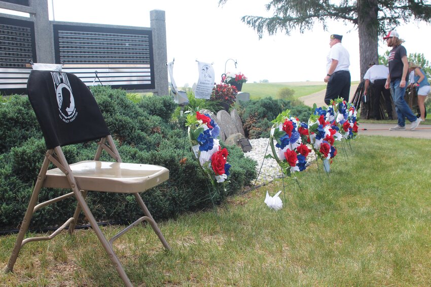 Wreaths stand in a line from the vacant POW-MIA seat.