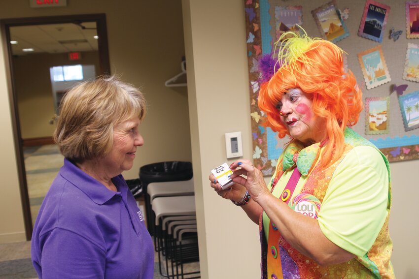 Loli Pop has some fun with the library's own DeAnn Kruempel at a summer program last year.