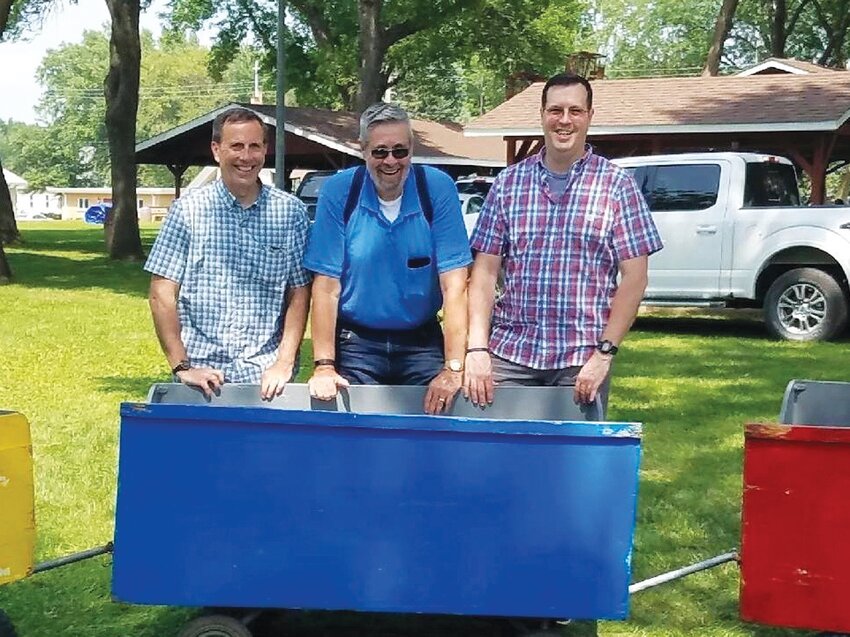 Pictured with a train car in 2018, from left to right: Doug Stockstad, Phil Stockstad and Douglas Stockstad.