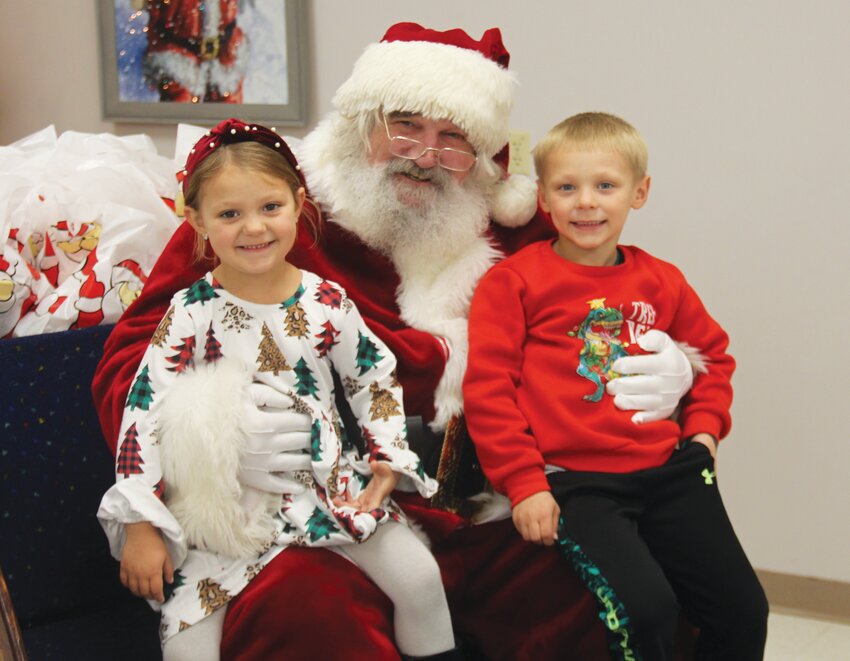 Charlotte and Tanner Leonard smile with Santa at the Rand Community Center during Merry Main Street.