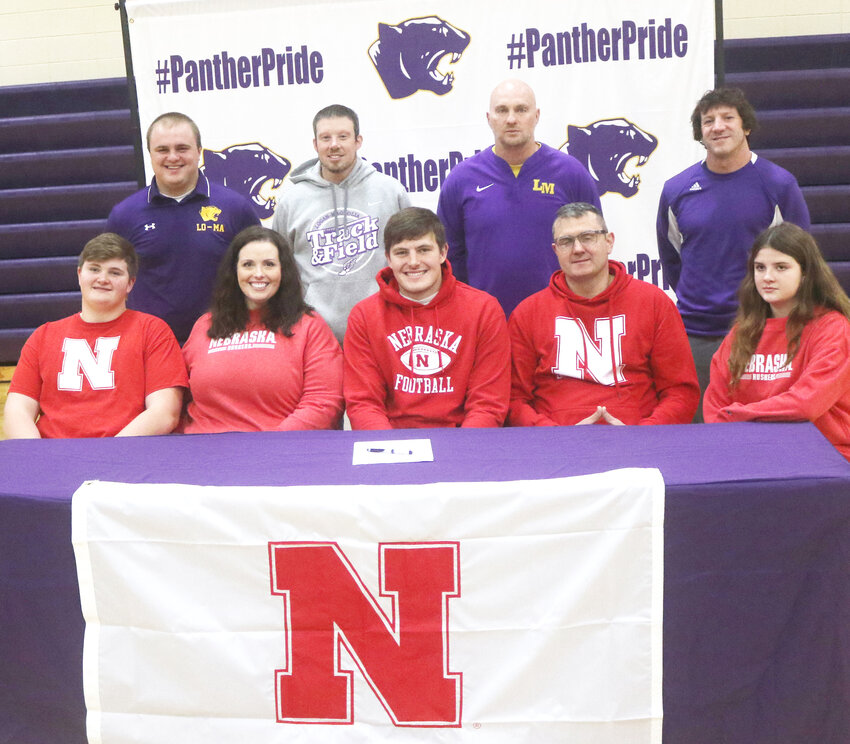 Logan-Magnolia's Grant Brix (front, center) signed his letter of intent on Dec. 20 to continue playing football at the University of Nebraska (Linclon, Neb.).  He is seated in the front row with his family, Grady, Attalee, Grant, Jim, and Gwen Brix.  Standing in back, from left, Coach Barrett Pitt, Coach Joe Cooper, Coach Matt Straight, Coach Dan Thompson.