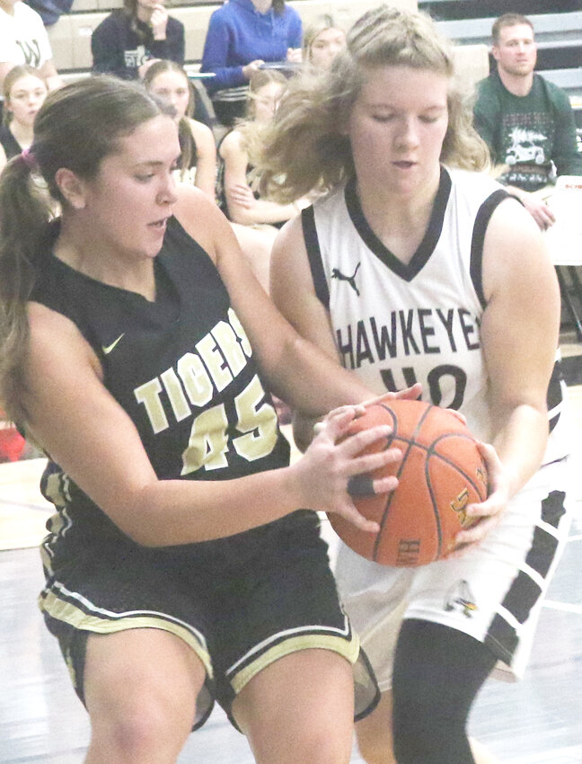 Woodbine's Madison Thomas (45) and West Harrison's Danielle Cooper (40) battle for possession of the ball in Rolling Valley Conference action on Dec. 21 at Mondamin.