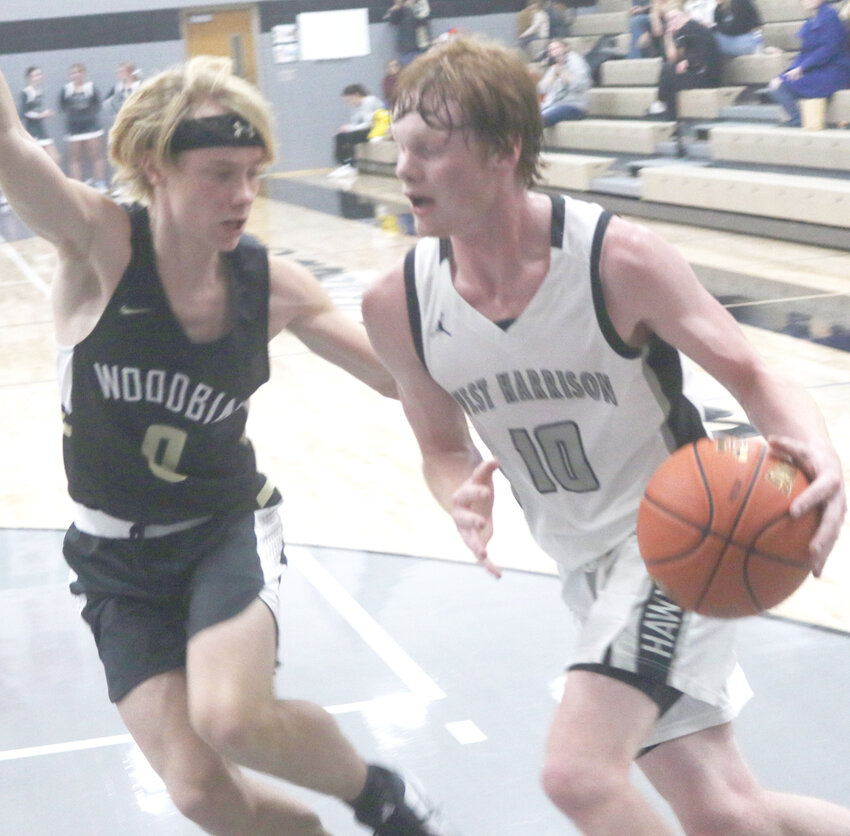 West Harrison's Jacob Barry (10) drives past Woodbine's Gunnar Wagner in Rolling Valley Conference play on Dec. 21 in Mondamin.