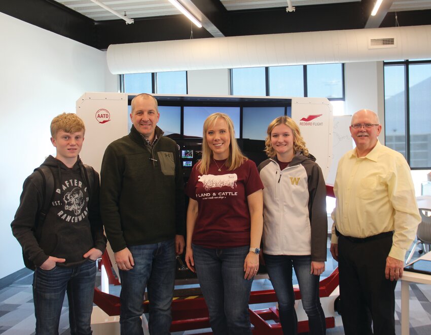 Pictured in front of one of IGNITE Pathway's flight simulators, from left: Cody Dickinson, Sec. Mike Naig, Starlyn Perdue, Lilly Kerger and Curtis Lee.
