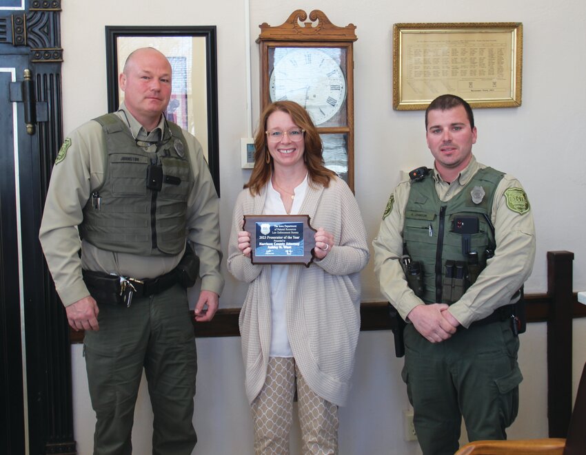 County Attorney Ashley West receives the 2023 Prosecutor of the Year Award from the Iowa DNR. Pictured from left to right: Cpt. Eric Johnston, West and Conservation Officer Aaron Johnson.