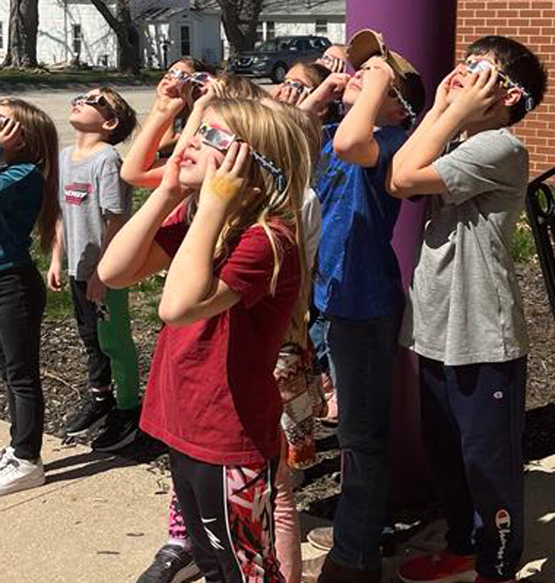 Mrs. Earlbacher's second grade class takes a look at the solar eclipse on Monday in Dow City.