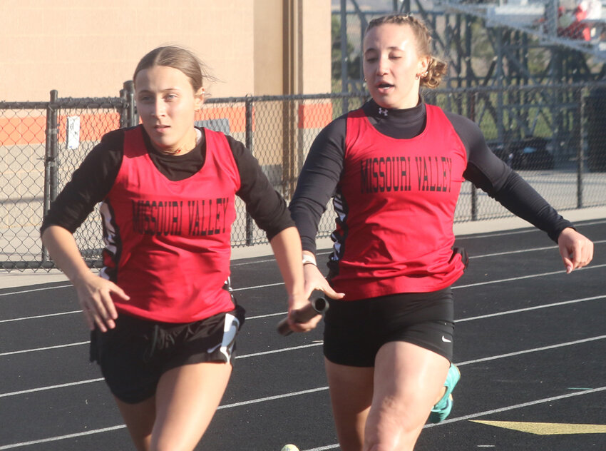 Missouri Valley's Crystal Martinez takes the baton from Mia Hansen in the 4 x 200 m relay at the Lady Reds Relays on April 23 at Missouri Valley.