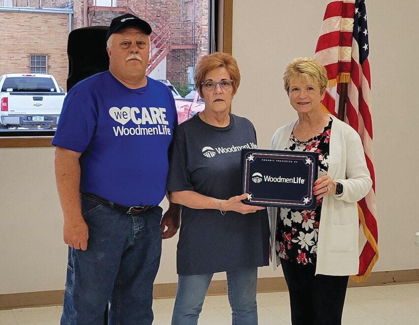 Henry Fox (left) and Mary Jo Buckley (middle) present a flag for the Rand Community Center to Jeannie Wortman.