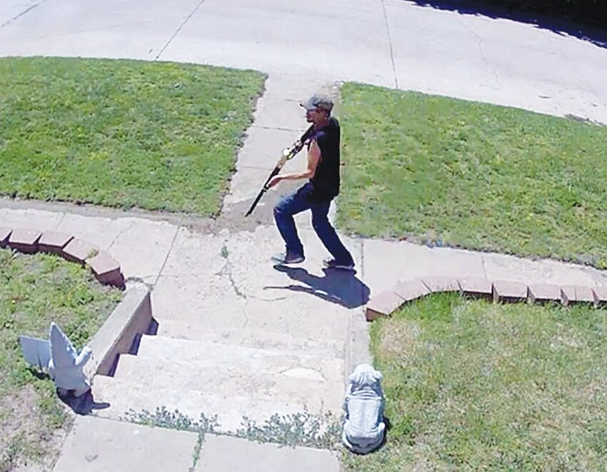 A zoomed in screenshot of the White's front yard security footage allegedly shows Jordan running across their front sidewalk with a weapon.