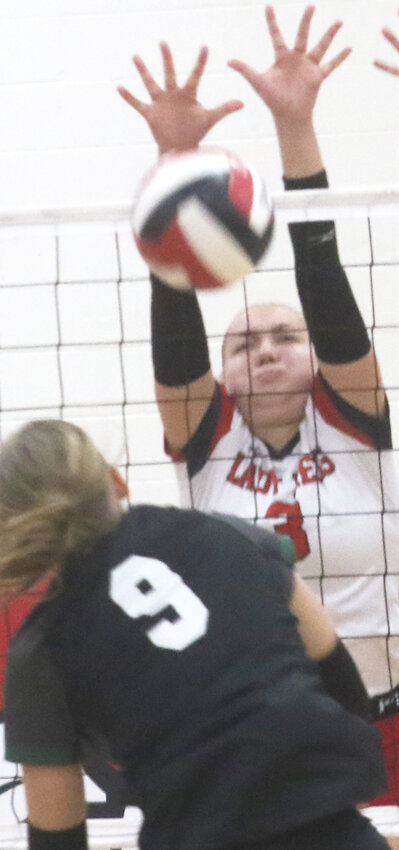 Missouri Valley's Madee Kierscht (3) blocks the hit attempt during the Western Iowa Conference Tournament consolation finals on Oct. 15 at Missouri Valley.  The Lady Reds opened up Class 2A Regional Tournament play on Oct. 21.