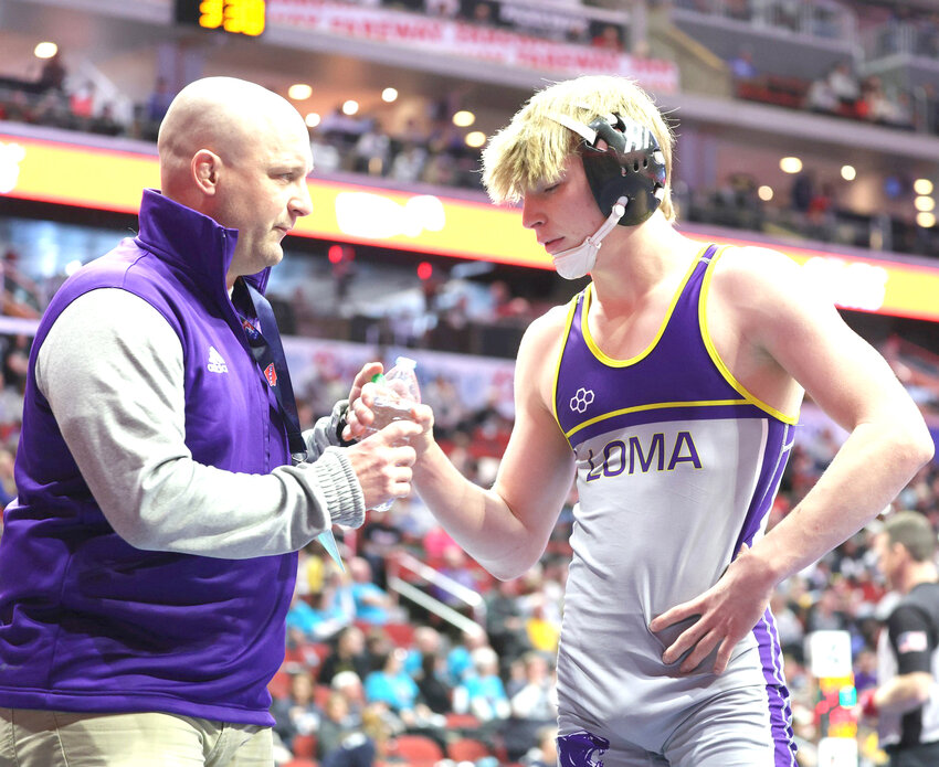 Father-Son Moment:  Lo-Ma Coach Jeff Kuhl and Kalab Kuhl share a moment while discussing strategy during the 2025 State Wrestling Championships in Des Moines.