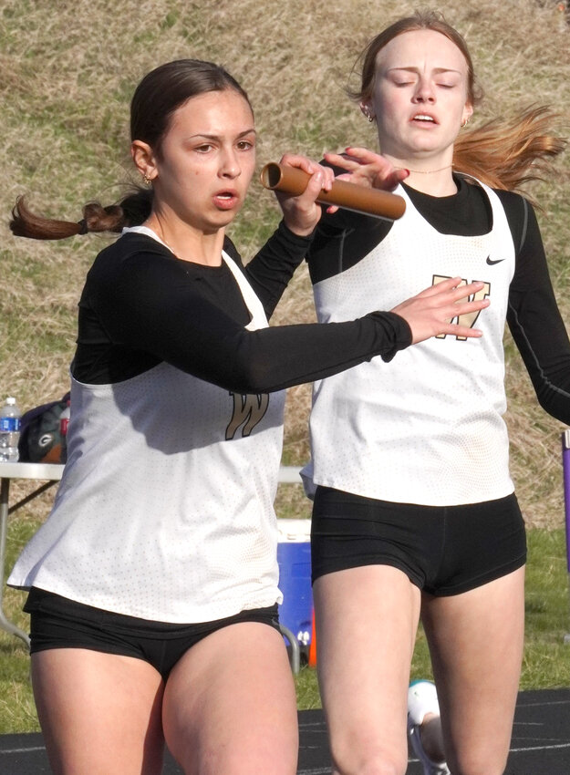 Woodbine's Charlotte Placek takes the baton from Izabell Seda at the Monarch Relays in Denison on April 3.