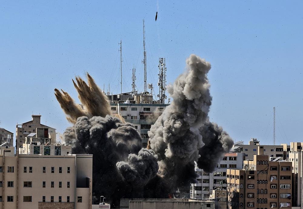 An air bomb hits the building housing various international media, including The Associated Press, in Gaza City, May 15, 2021. Israel’s defense minister has distanced himself from comments made by his military chief after Israel bombed the Gaza Strip high-rise housing an AP office and other news outlets. (Mahmud Hams /Pool Photo via AP)