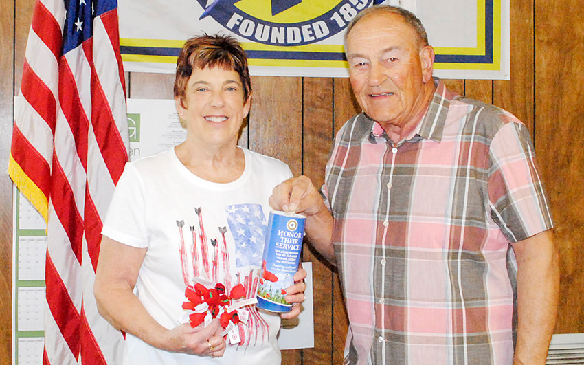 Wilton Mayor Bob Barrett (right) receives a memorial poppy from auxiliary member Becky Hansen (left). Poppies will be distributed, in exchange for donations, to area businesses by members of the American Legion Auxiliary Post #584. The poppies will also be available during Smorgasbord on May 15. Money collected will go to assist veterans and their families. Veterans make each 9-piece poppy.