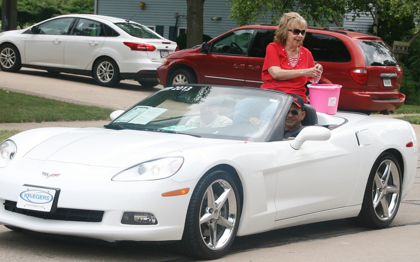 Parade co-grand marshal Fae Harvey throws out some candy. Her husband Norm rode shotgun.