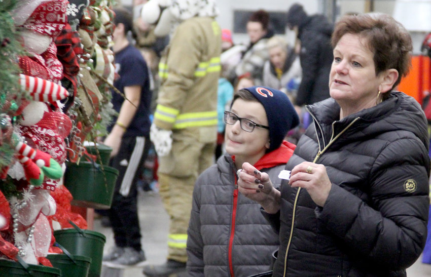 Cindy Arp and grandson Tyson Laughlin, of Eldridge, admire the wreaths on display at the Eldridge Fire Department during Hometown Holidays.