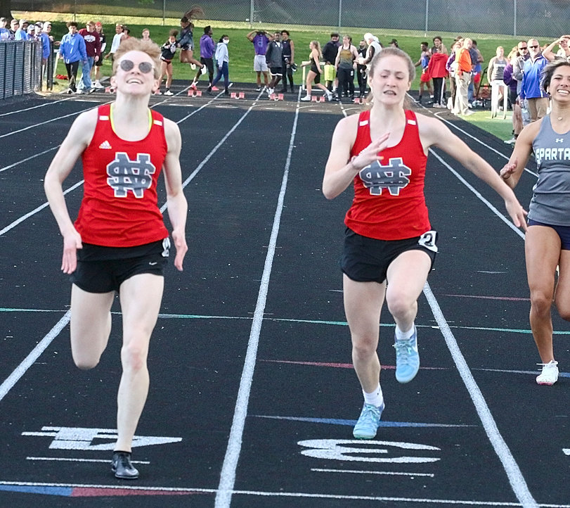NS junior Athena Nelson (l) and freshman Mercie Hansel finished one-two in the 100 meter dash at Thursday's district meet. Nelson will compete in four events at this week's state meet, while Hansel will run in three.