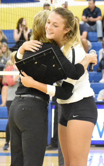 Wilton senior setter Ella Caffery recently broke the school record for assists, with her 2,190th at the Wapello tournament last week. As she adds to her career assist mark, she was honored before Wilton's home match with Regina Sept. 2. She was presented a plaque by head coach Brenda Grunder as the two are shown embracing.