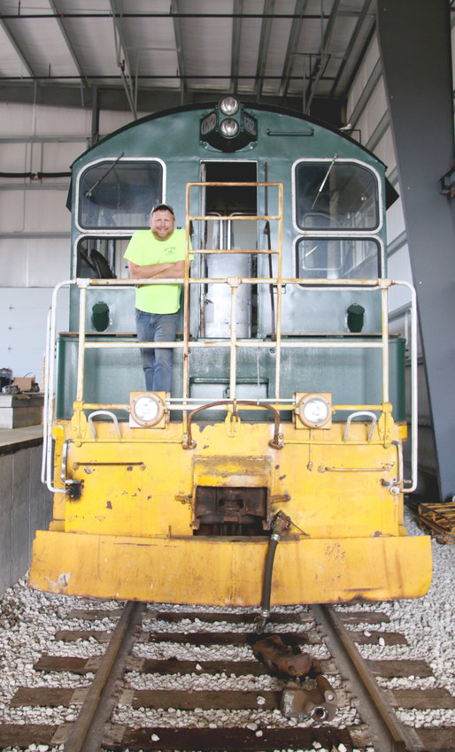 Steve Berish poses atop the Davenport Industrial Railroads 1951 locomotive. The  company is restoring the diesel-fueled, electric-powered engine to move rail cars over Eldridge tracks.