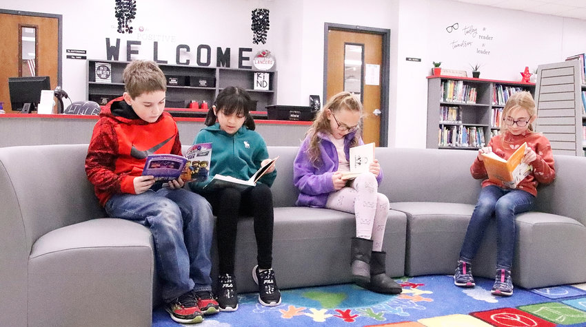 The John Glenn Elementary library underwent a major makeover last summer, and became an inviting place for students, from left, Ryan Phillips, Dulce Vargas-Tellez, Mya Sarazin and Elena Skadal to enjoy books.