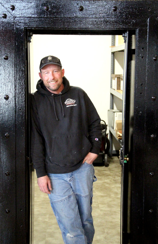 Damien &quot;Buzz&quot; Koehn poses in the vault of the old bank that now serves as city hall.