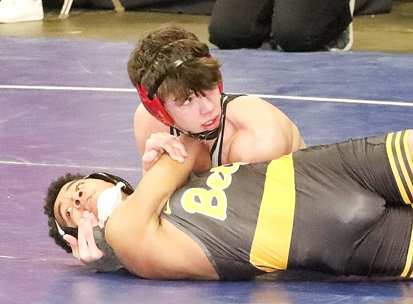 Three-time state placewinner Peyton Westlin looks at the clock as he puts the finishing touches on this first-round pin of Bettendorf's Elijah Mendoza.