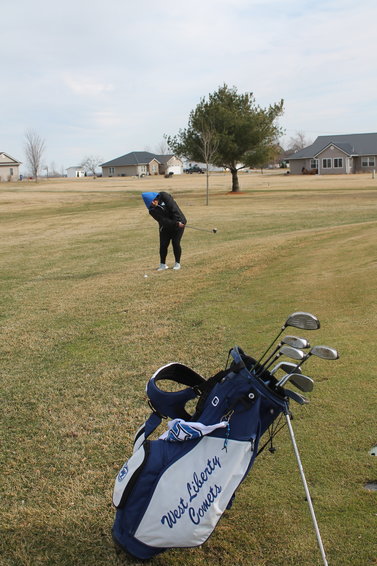 A member of the Comet girls golf team gives it her best shot in West Liberty Monday.