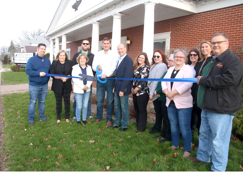 North Scott/Eldridge Chamber of Commerce members join Patrick Reid, center, as he snips a ribbon Tuesday morning to open the Thrive Professional Building, 220 W. Davenport St. Eldridge mayor Frank King, right, joined in, along with Reid's business partners Jeff and Sharon Newburn, and Thrive staff Patty Tank and Amanda Kelley.