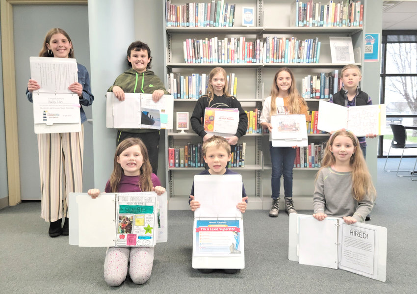 Students share favorite pages from their leadership portfolio at the April 11 Wilton school board meeting. Front, from left: Quinn Sawyer, Maverick Stranberg, and Lillian Ellithorpe. Back, from left: Hailey Lies, Grady Oien, Brylee Brandies, Everleigh Grunder, and Logan Lies. Photo by Kimberly Sloan