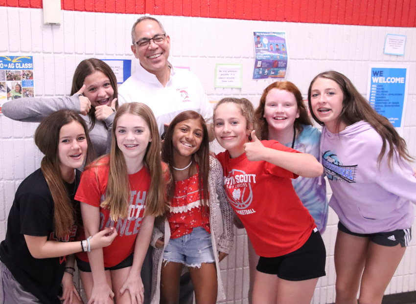 North Scott Junior High principal John Hawley takes time to strike a pose with this group of seventh-grade girls during lunch on Friday. From left: Lily Lenninger, Jaelyn Watts, Katelyn Kuesel, Olivia Graham, Macy Robertson, Nora Davis and Abby Holst.