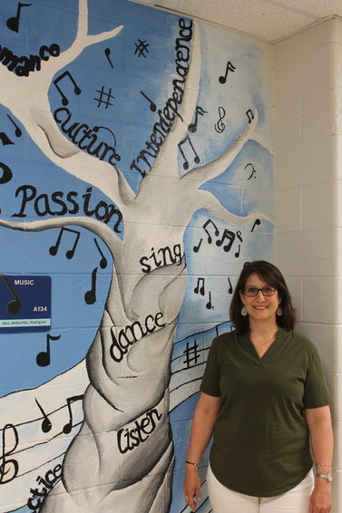 Standing next to a musical mural outside of her classroom, West Liberty Middle School vocal music instructor Brenda Miller will be retiring after 34 years of teaching.