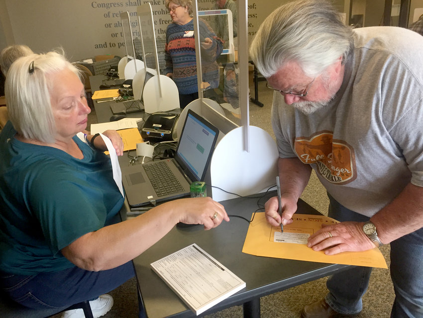 Margie Biddick, of Eldridge, confirms registration for Lyman Miller, May 18 during early voting at the Scott County Library. County elections official James Martin said 60 voted in Eldridge on May 18.