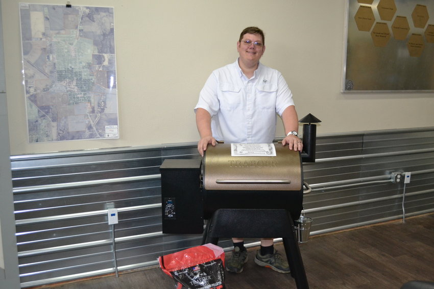 WeLead Executive Director and Rotary member Ken Brooks with one of the raffle items for the Gala, a Traeger Grill and Smoker.