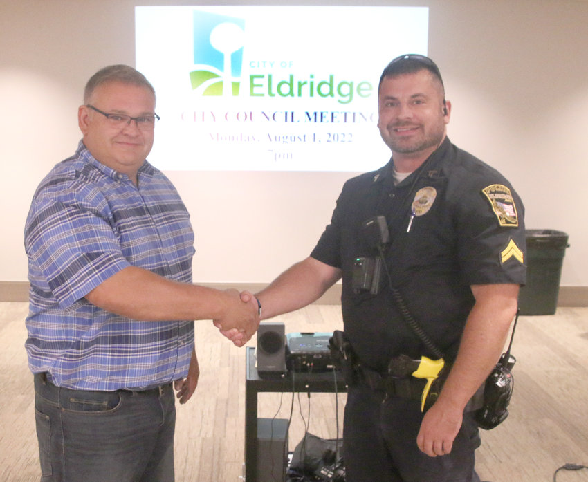 Eldridge Mayor Frank King and police corporal Tony Cavanaugh commemorate the council's National Night Out Proclamation before the Aug. 2 event at Sheridan Meadows Park. Deputy chief Andrew Lellig said the night celebrates community partnerships for public safety and crime fighting.