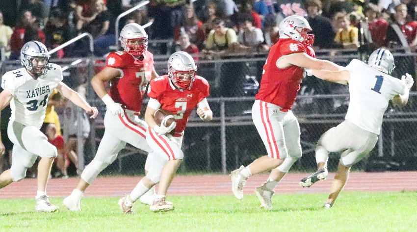 Sandwiched between Nate Schneckloth (75) and David Borchers (72), Lancer senior Drew Kilburg picks up 28 yards after hauling in a pass from quarterback Kyler Gerardy.