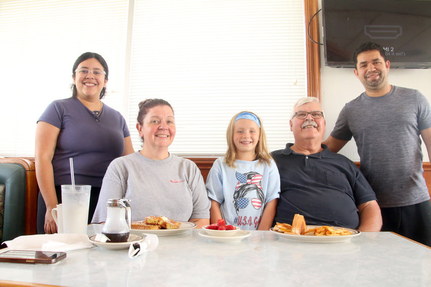 Claudia O'Connor, left, and Alex Perez, pose with regular customers Karen and Joe McKeown, with granddaughter Elli Thuenen.
