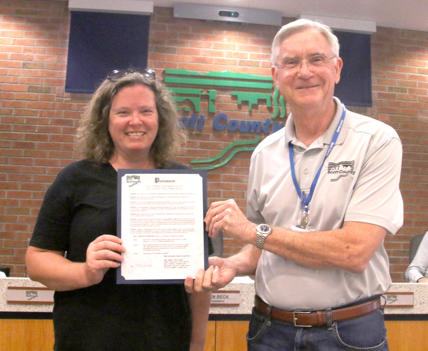 Ann McGlynn, of Tapestry Farms, accepts a welcoming week proclamation from Scott County Board Chairman Ken Beck, Sept. 15.