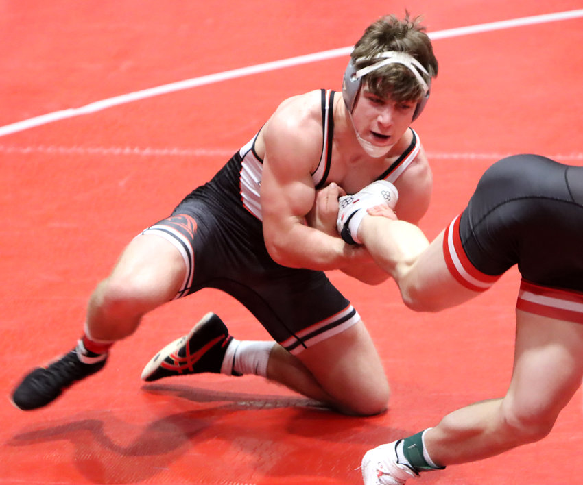 Senior Seth Madden snags the foot of Drew Burds of Western Dubuque during the semifinals of Saturday's district tournament.